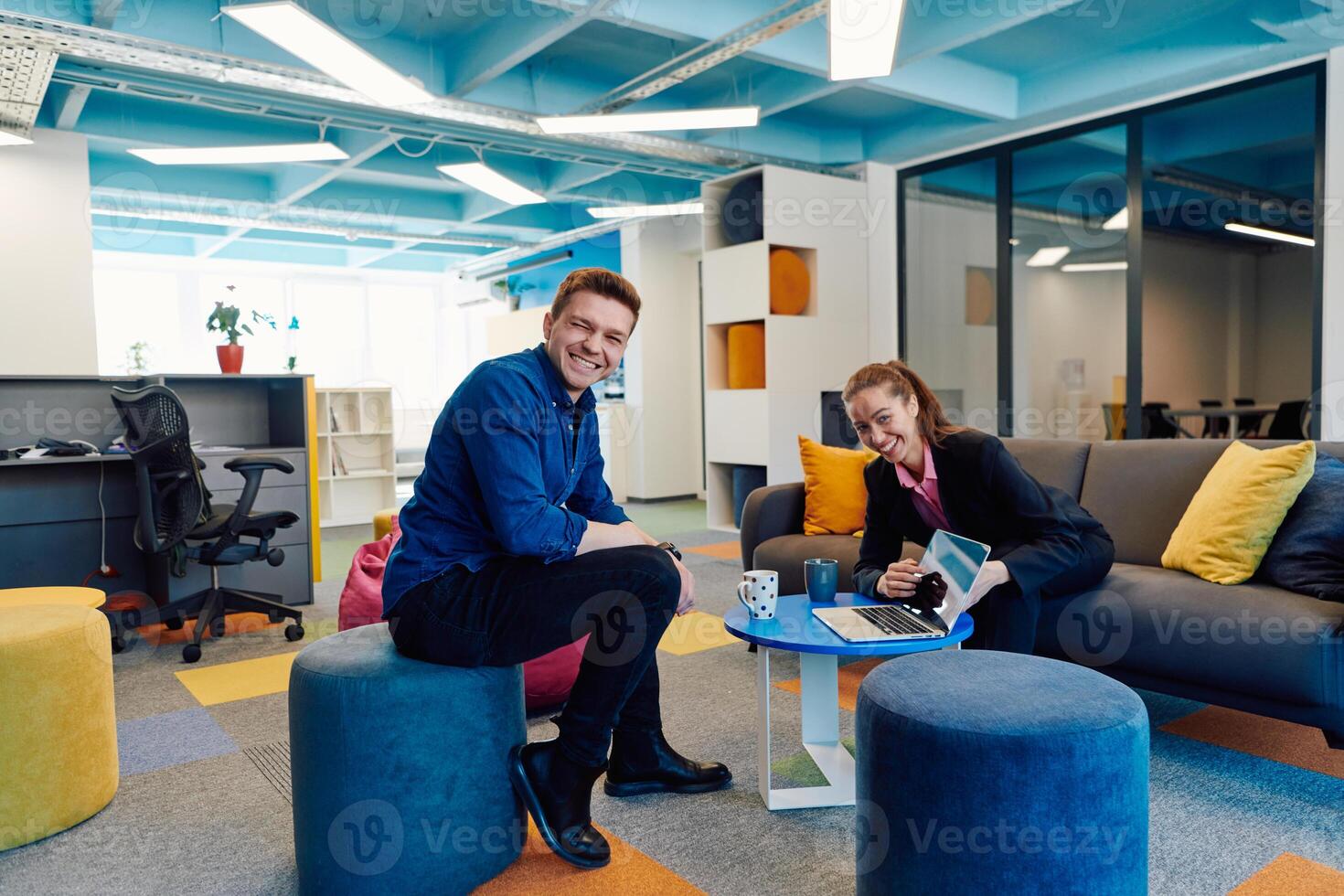 Multiethnic startup business team on meeting in a modern bright open space coworking office. Brainstorming, working on laptop. Group of coworkers walking around in motion blur photo