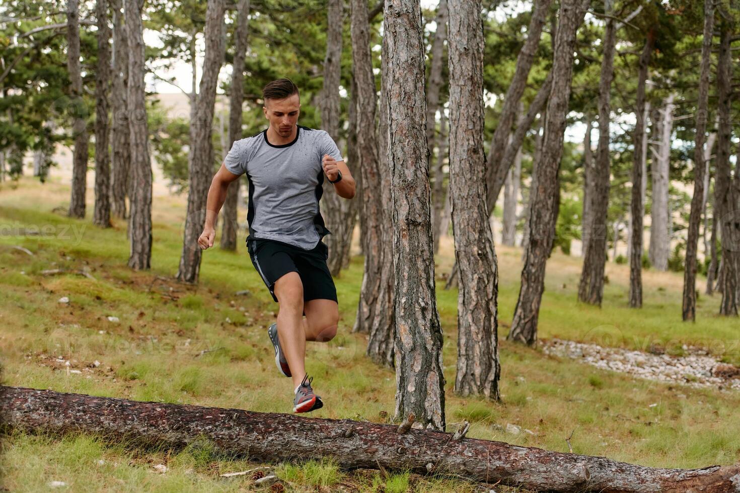 Determined Man Conquering Forest Obstacles with Grit and Speed photo