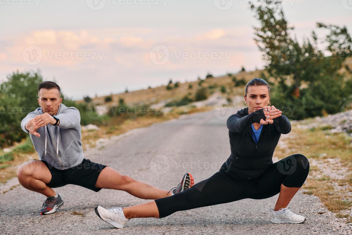 A Romantic Couple Stretching Down After a Run photo