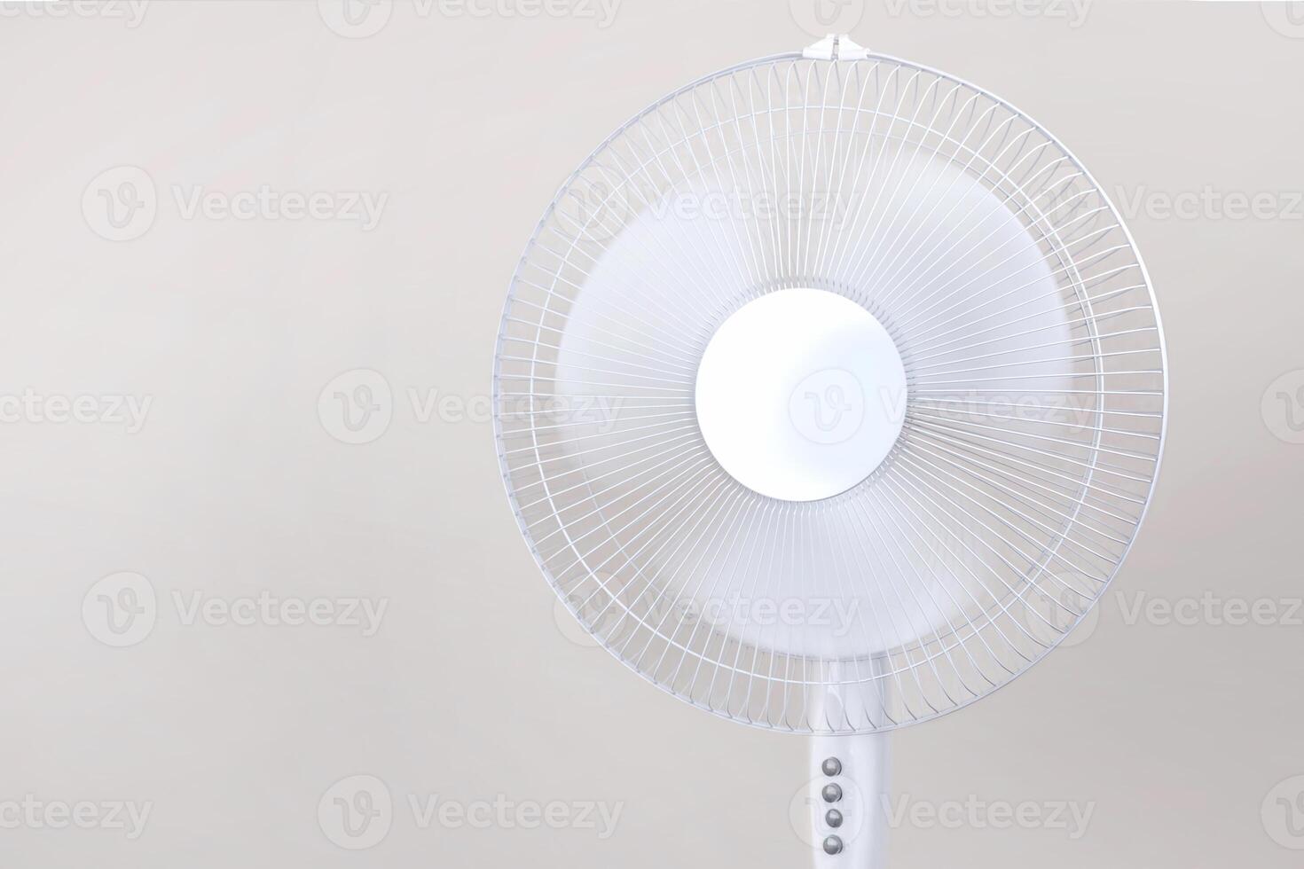 Electric Floor fan turned on white isolated on beige background. Relief from the heat, hot summer. Close up photo