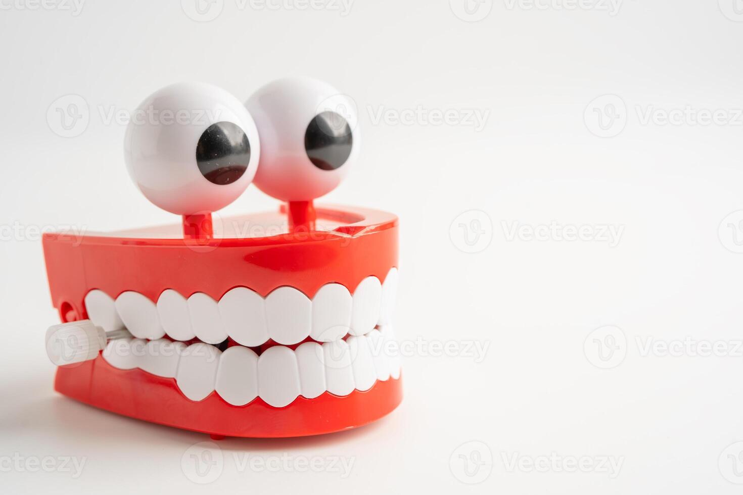 Tooth funny toy denture red color jaw and eye on whtie backgroud with copy space. photo