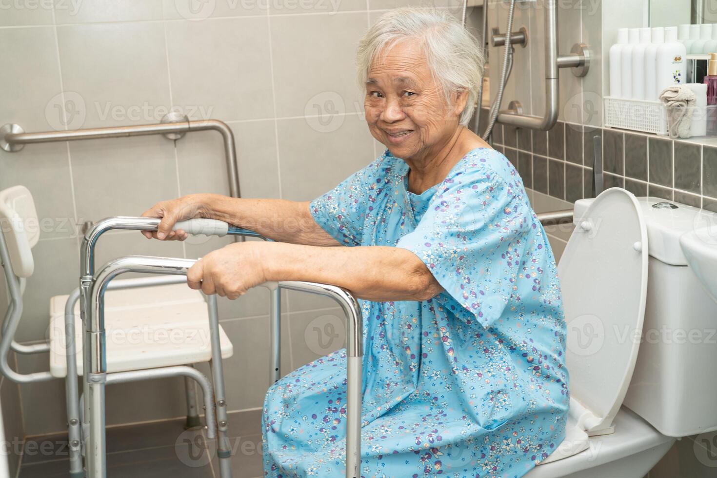 Asian elderly woman patient use toilet bathroom handle security in nursing hospital, healthy strong medical concept. photo