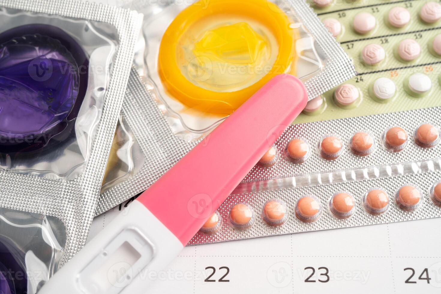 Pregnancy test and birth control pills on calendar, contraception health and medicine. photo
