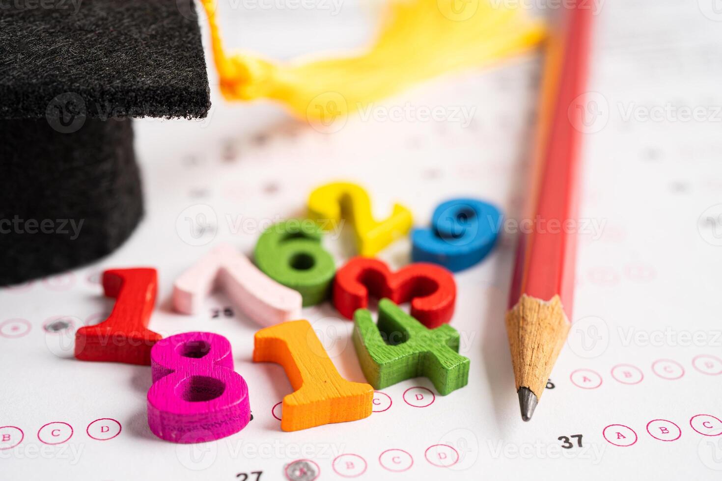 Graduation gap hat and pencil on answer sheet paper, Education study testing learning teach concept. photo