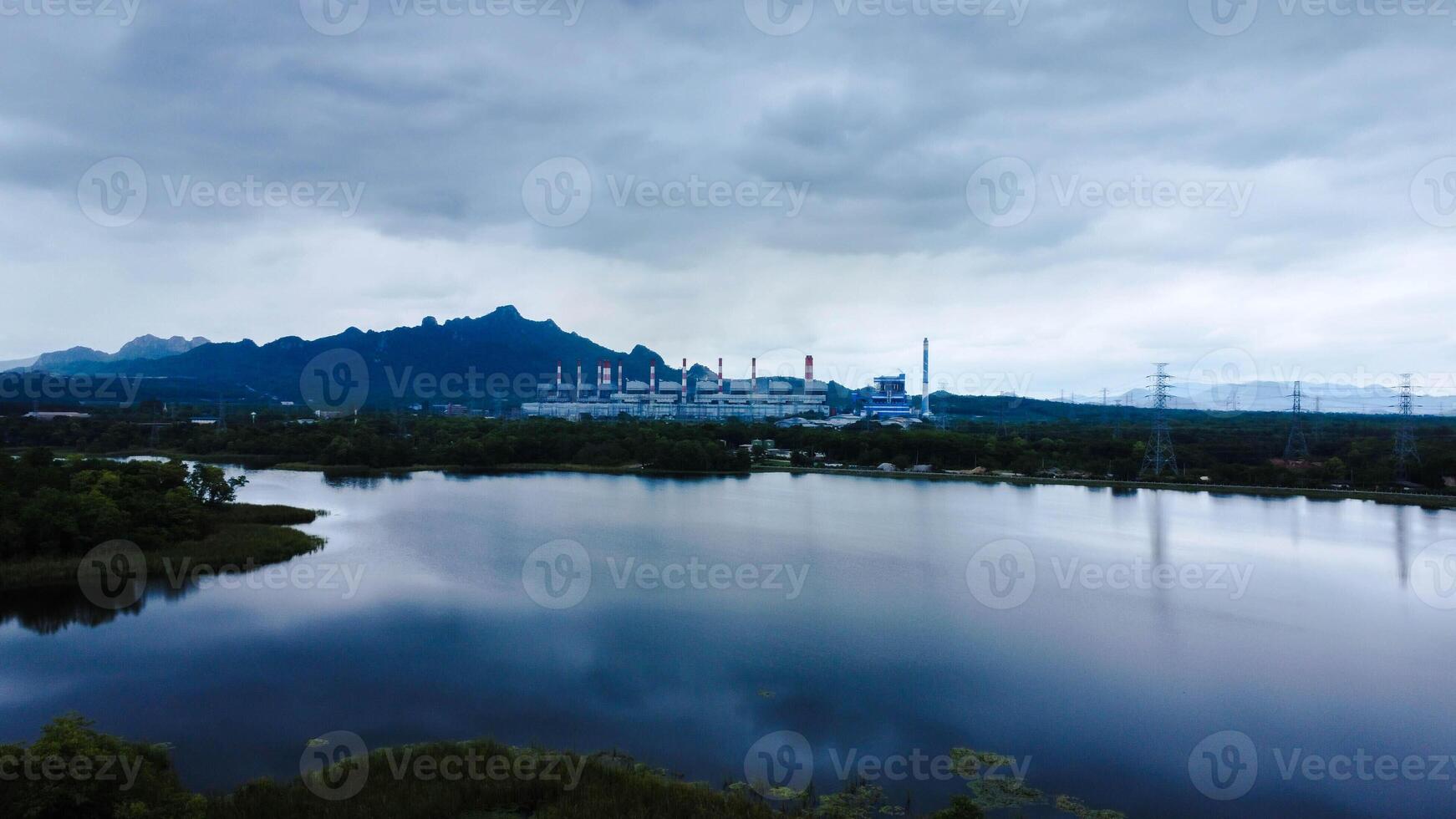 Landscape of the Mae Moh coal-fired power plant in Lampang, Thailand, with a view of the reservoir and a sky with clouds. photo