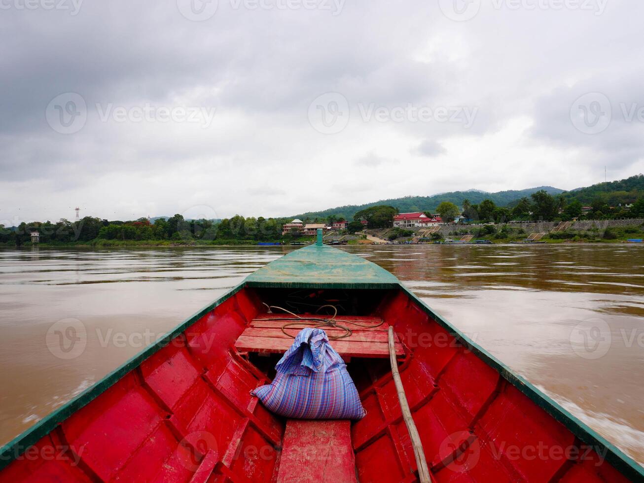 View on a local passenger boat sailing on the Mekong River with views of nature and Lao villages. photo