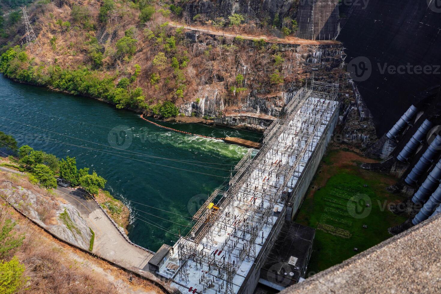 River dam amidst beautiful landscape with bridge, mountains and trees in summer, power plant at Bhumibol Dam in Thailand. photo