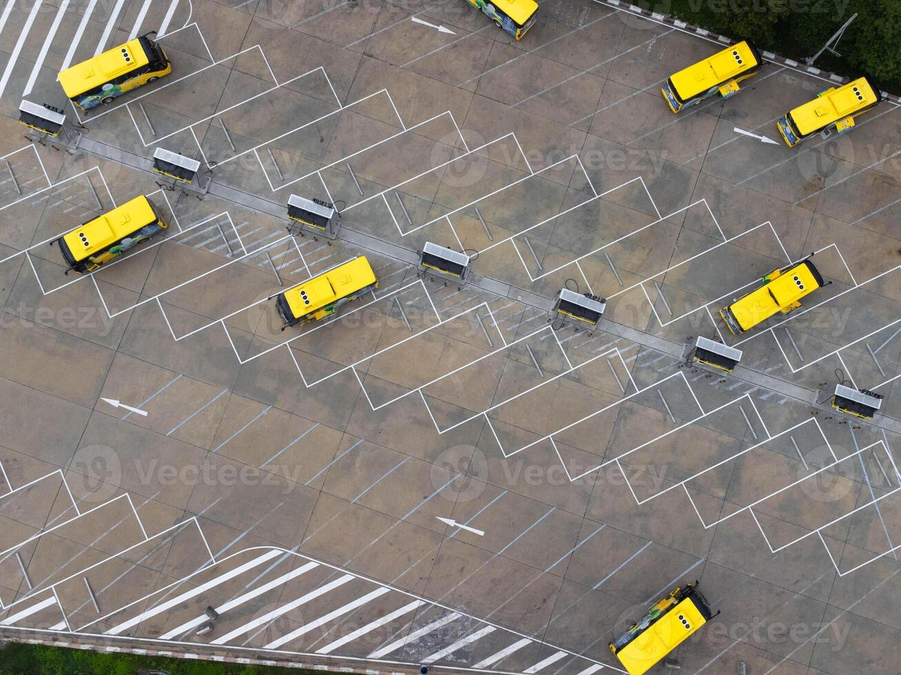 Aerial view of the electric bus charging station. Yellow electric city bus charging parking at charger station with plug cable. Electrified transport future mobility e-motion. photo