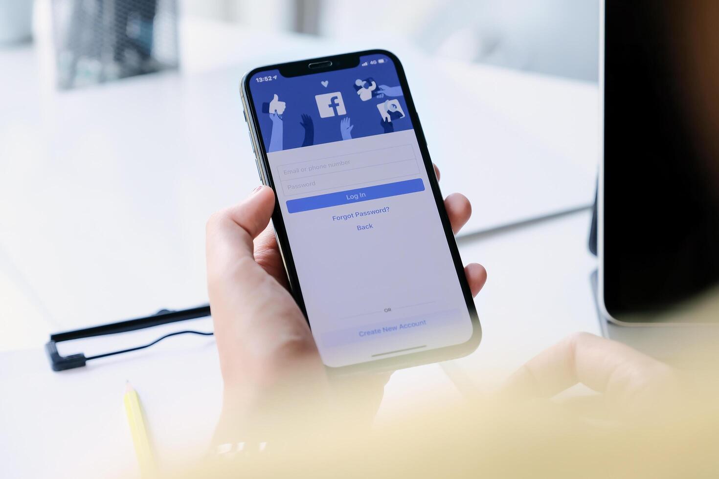 CHIANG MAI ,THAILAND - MAR 7, 2020 . Woman hand holding iPhone XS to use facebook with new login screen. photo