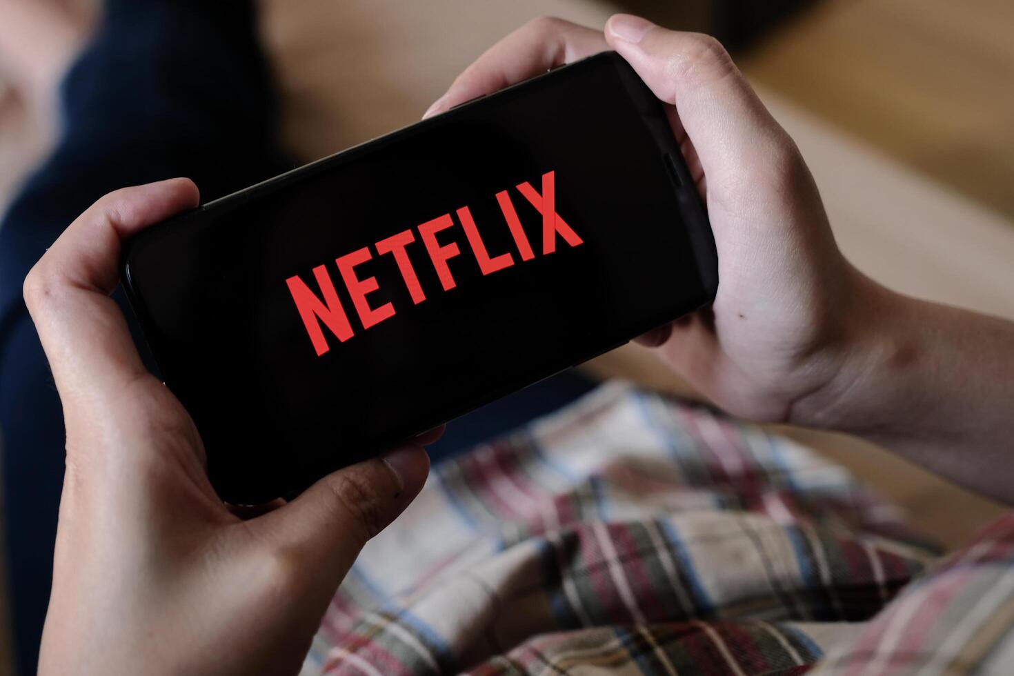 CHIANG MAI, THAILAND, MAR 29, 2020. Woman hand holding Smart Phone with Netflix logo on Apple iPhone Xs at home. photo