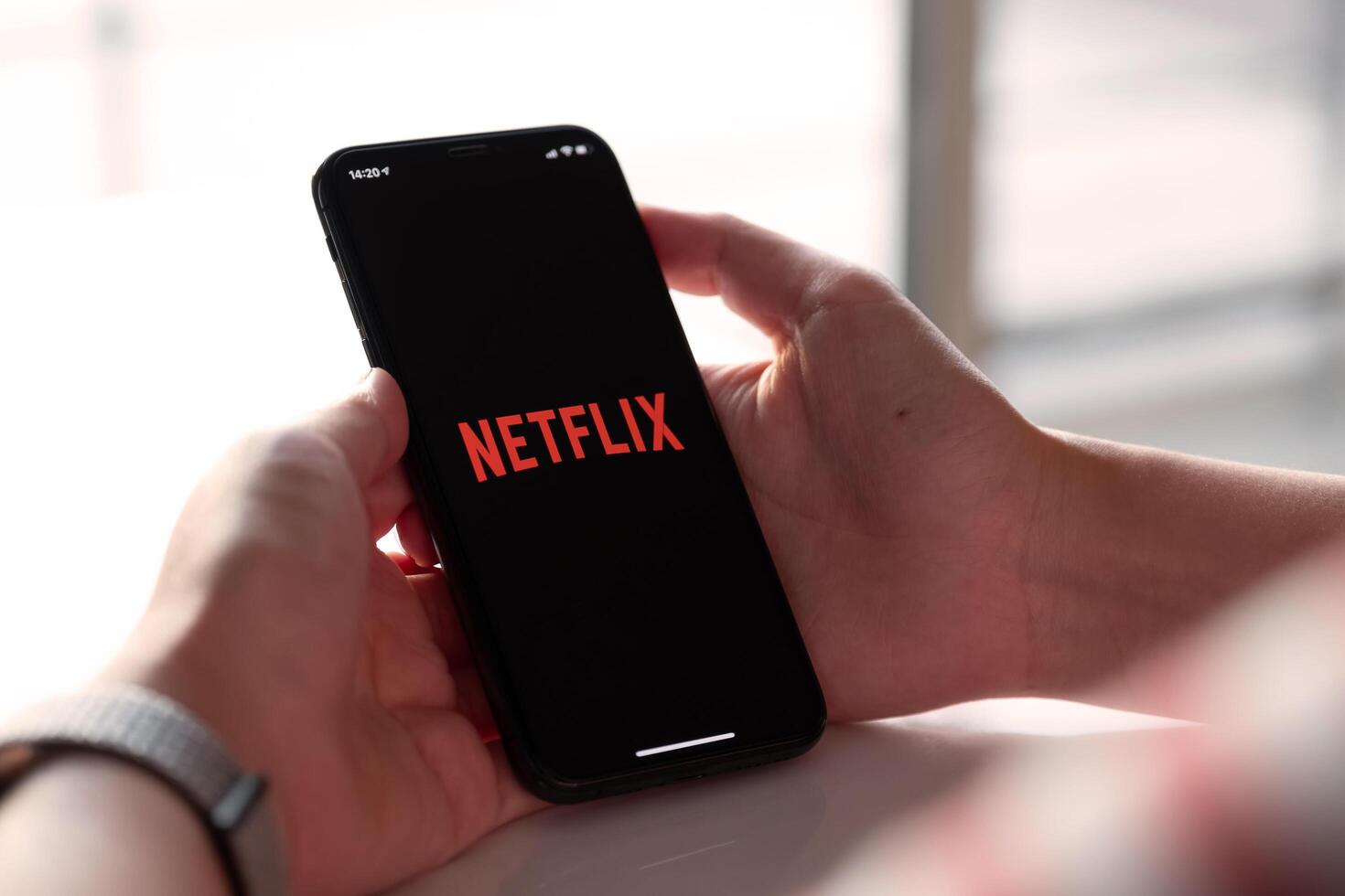 CHIANG MAI, THAILAND, NOV 17, 2019. Woman Smart Phone with Netflix iPhone Xs. photo