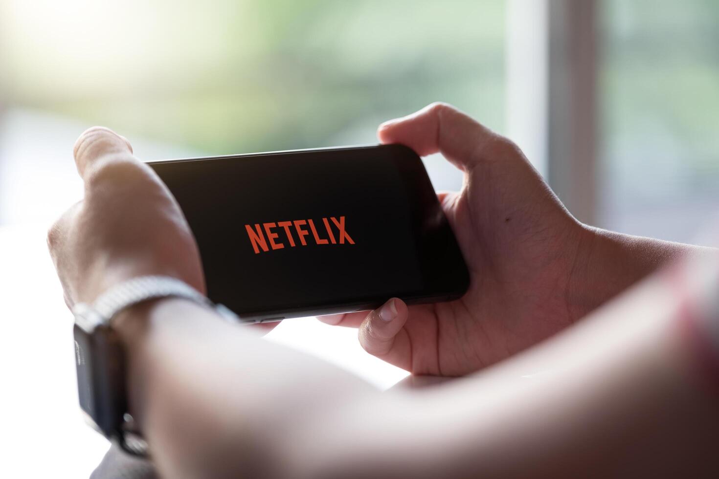 CHIANG MAI, THAILAND, NOV 17, 2019. Woman holding Smart Phone Netflix Phone Xs. photo