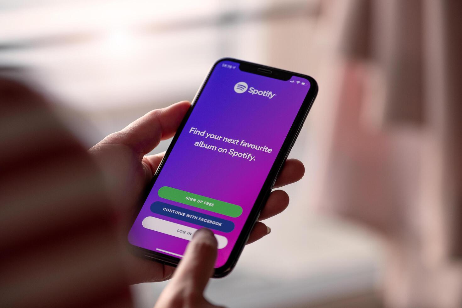 CHIANG MAI, THAILAND - NOV 17 2019. Person holding Apple iPhone XS with Spotify photo