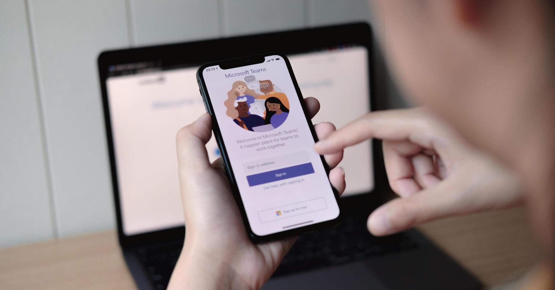 CHIANG MAI, THAILAND - JUN 22, 2020 . female touching iPhone with LinkedIn screen. LinkedIn helps build resume and look for a new job photo