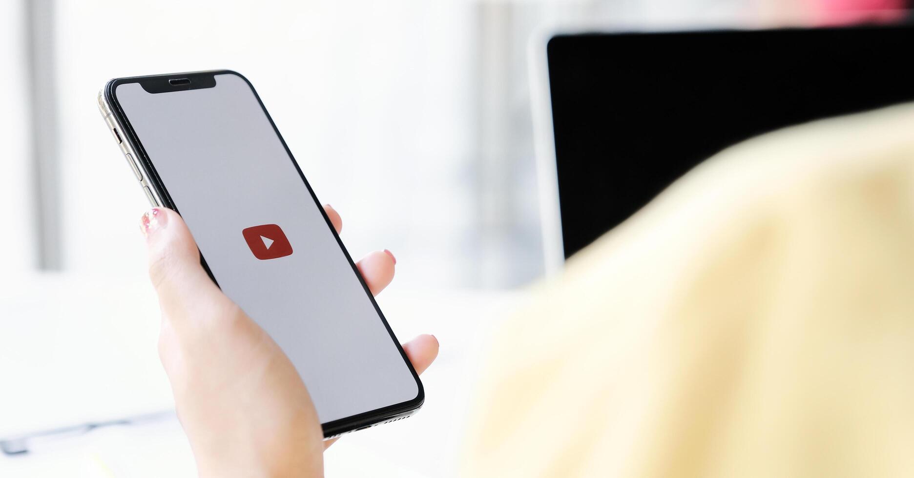 CHIANG MAI, THAILAND - MAR 7 ,2020. Woman holding iPhone Xs with Youtube apps on screen. YouTube is the popular online sharing website. photo