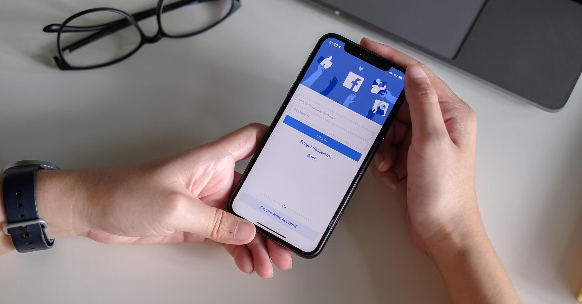 CHIANG MAI ,THAILAND - JULY 3, 2020 . Woman hand holding iPhone X to use facebook with new login screen.Facebook is a largest social network and most popular social networking site in the world photo