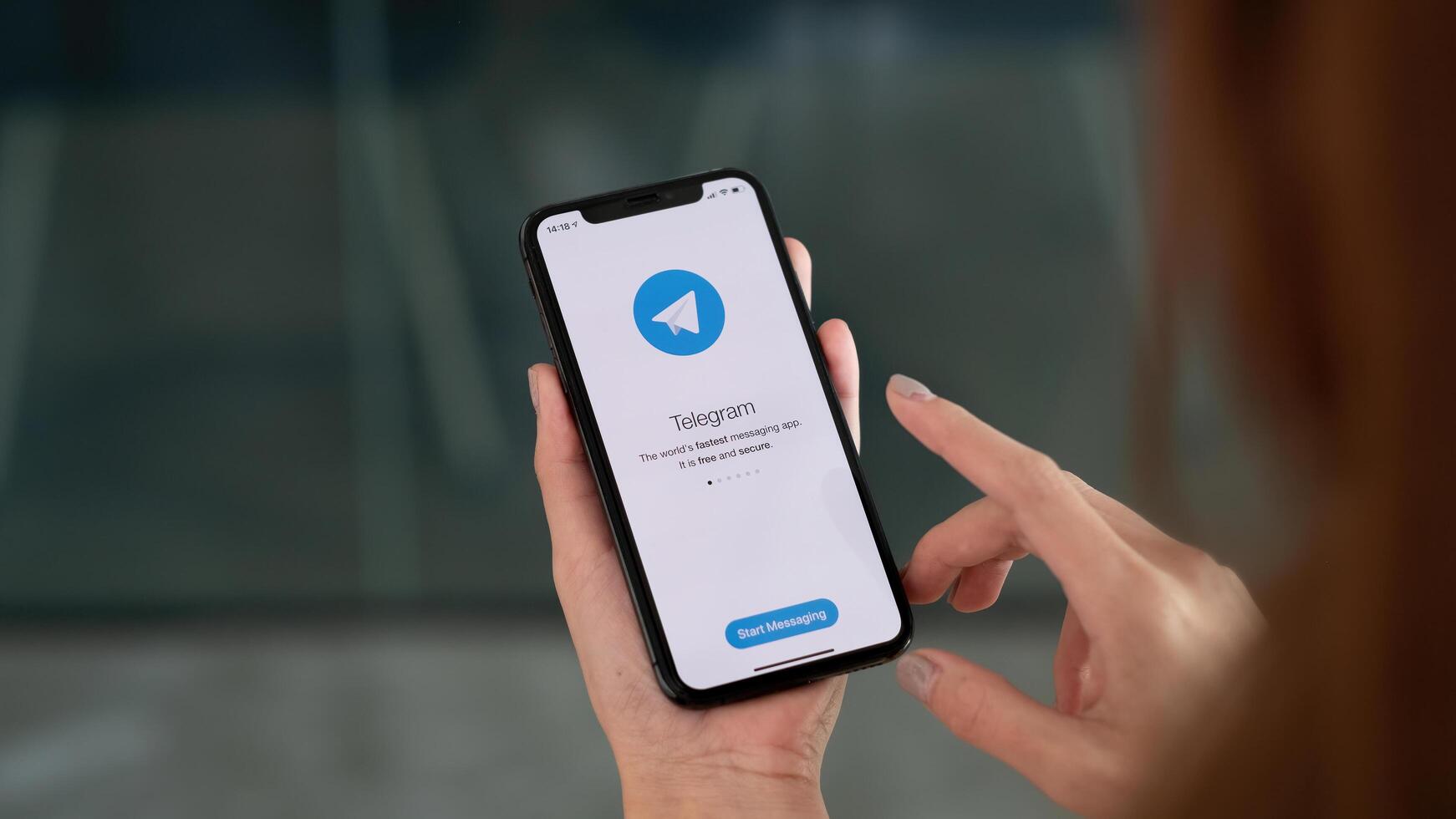 CHIANG MAI, THAILAND, OCT 3, 2021 . Woman hand holding iPhone X with social networking service Telegram on the screen. iPhone 10 was created and developed by the Apple inc photo