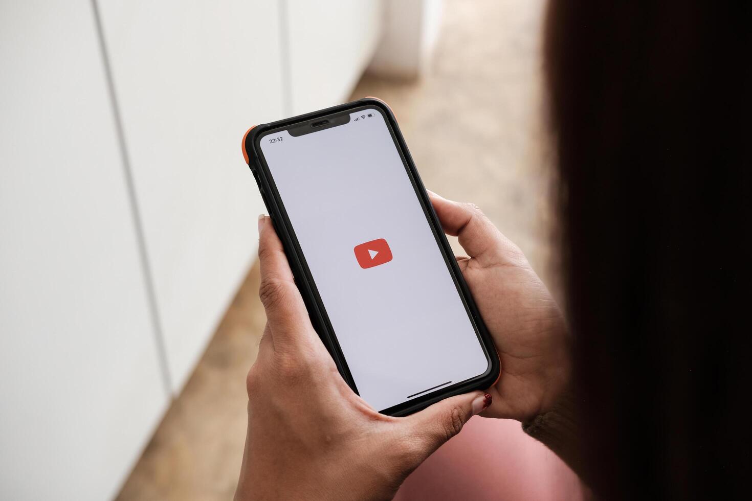 CHIANG MAI, THAILAND - NOV 7, 2021. woman holding iphone x with Youtube apps on screen. YouTube is the popular online sharing website photo