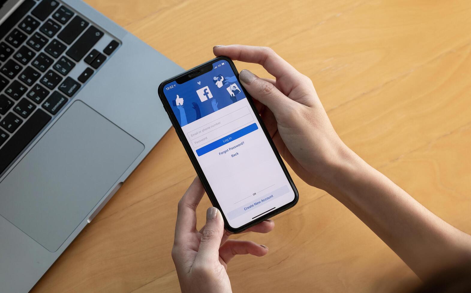 CHIANG MAI, THAILAND - OCT 03, 2018. Facebook social media app logo on log-in, sign-up registration page on mobile app screen on iPhone X in person's hand working on e-commerce shopping business. photo