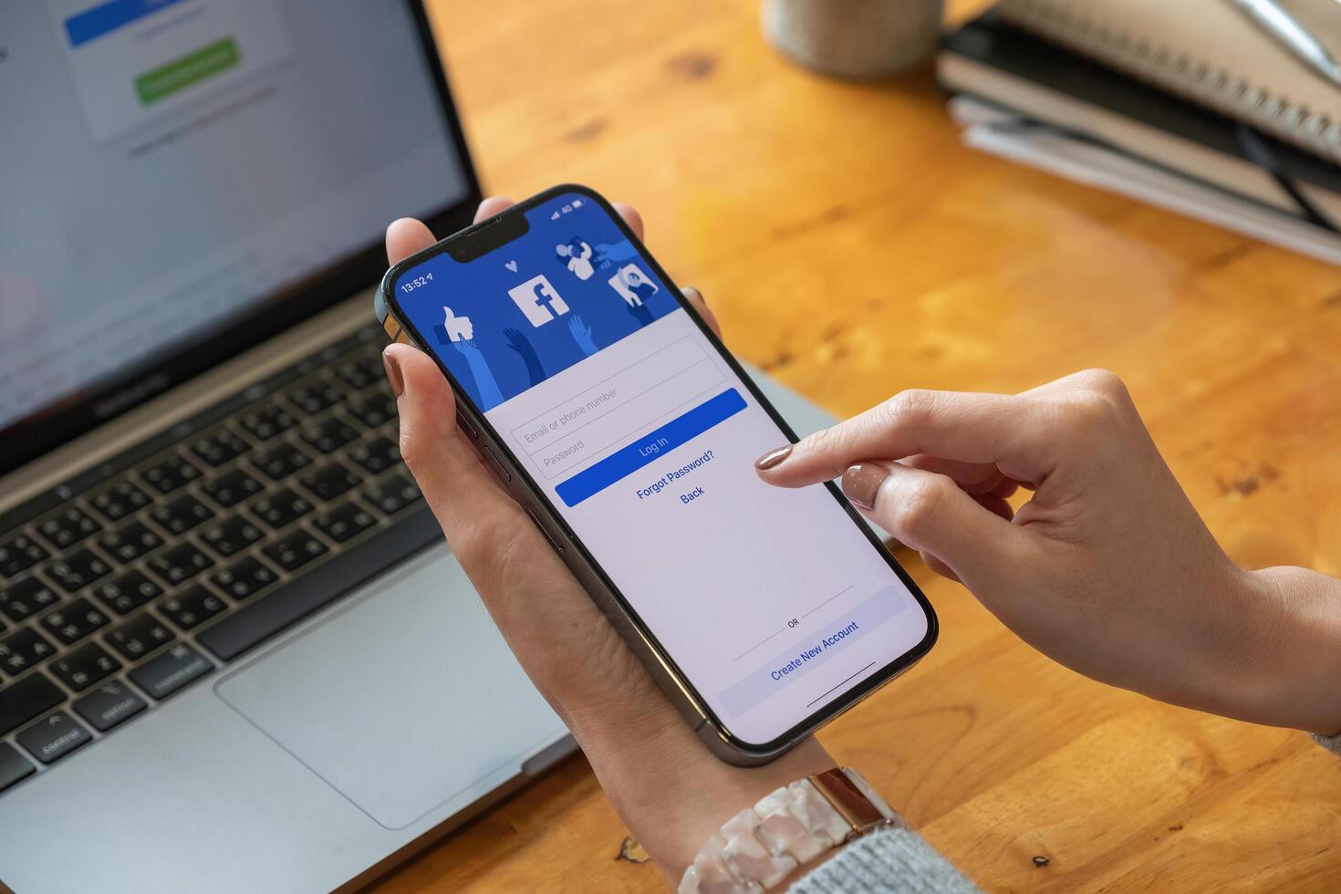 CHIANG MAI, THAILAND - OCT 17, 2021. Facebook social media app logo on log-in, sign-up registration page on mobile app screen on iPhone 13 Pro Max in person's hand working on e-commerce shopping. photo