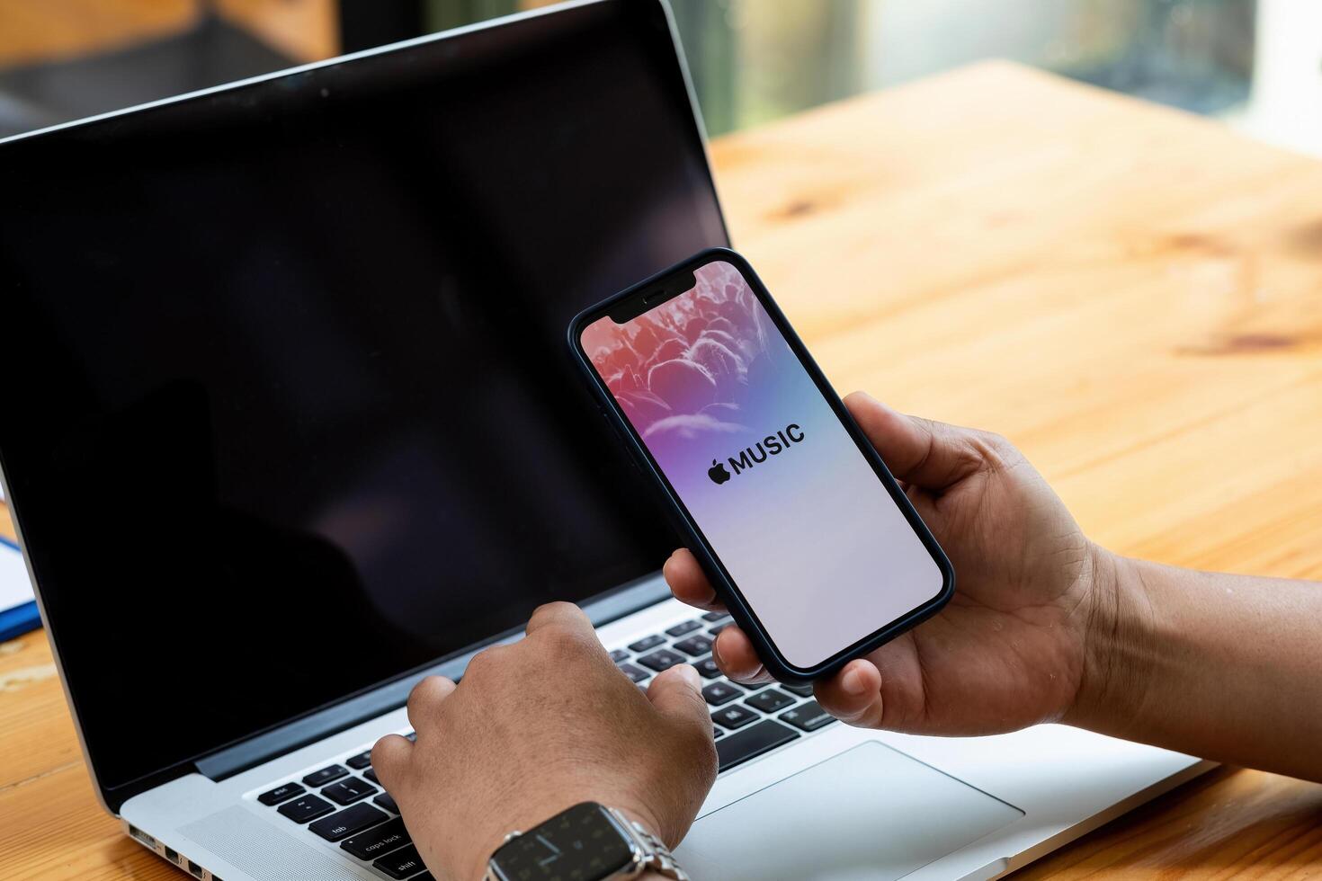 CHIANG MAI,THAILAND - AUG 22,2021. A man hand holding screen shot of Apple music app showing on iPhone 12. Apple Music is the new iTunes-based music streaming service that arrived on iPhone photo