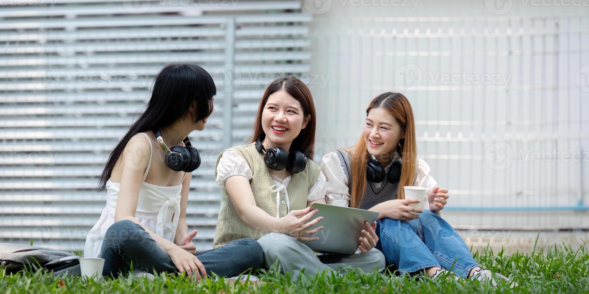 College student having discussion under tree on campus, preparing for exam, learning and reading books together photo