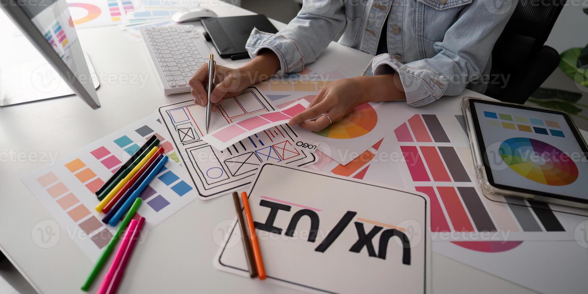 Stylish woman Ux designer using digital tablet and computer planning new website wireframe at creative home office photo