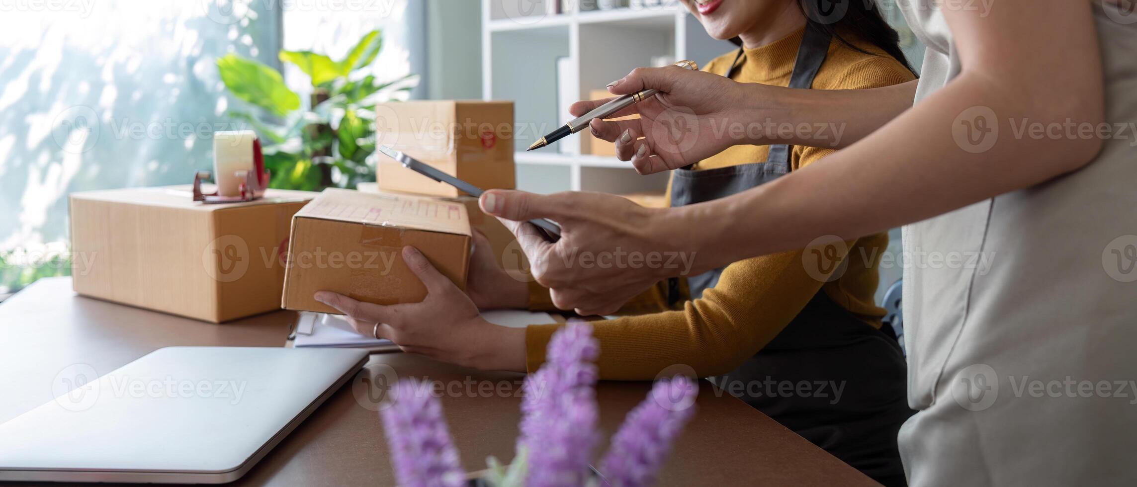 Entrepreneurs preparing packages in a bright home office photo
