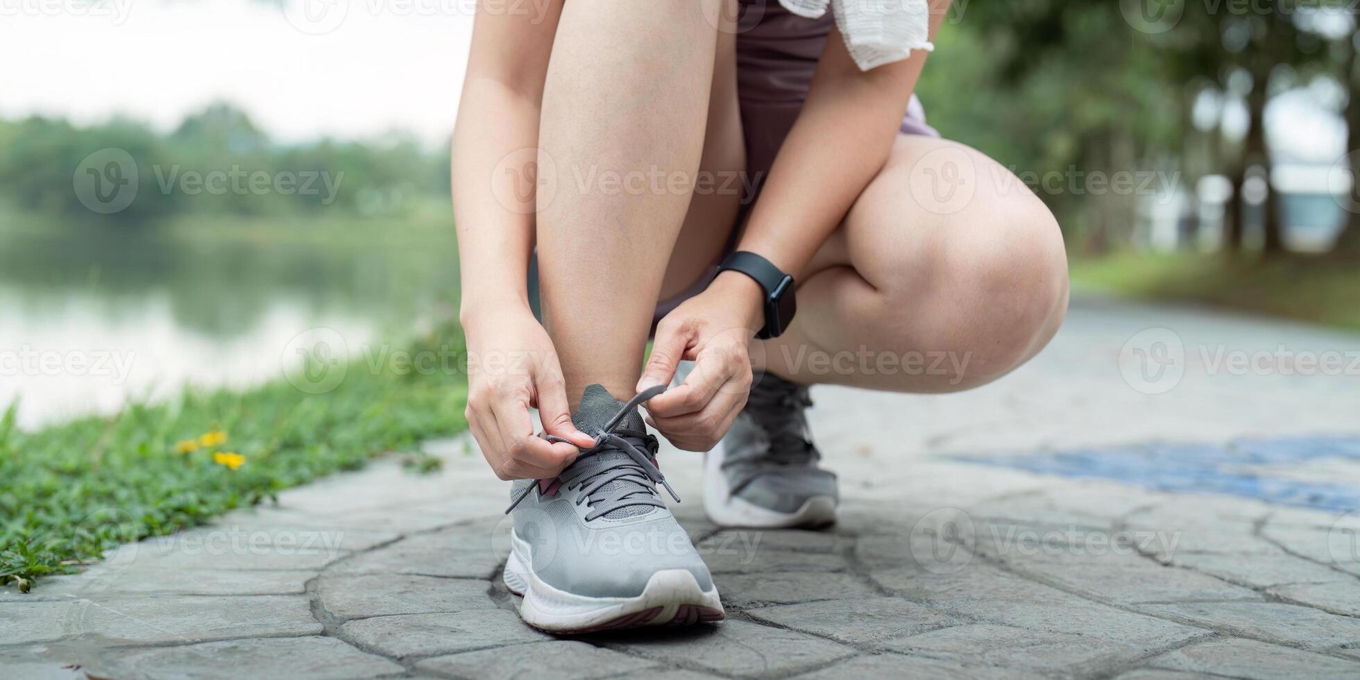 Young woman tying shoelace in the park. Sport and fitness concept photo