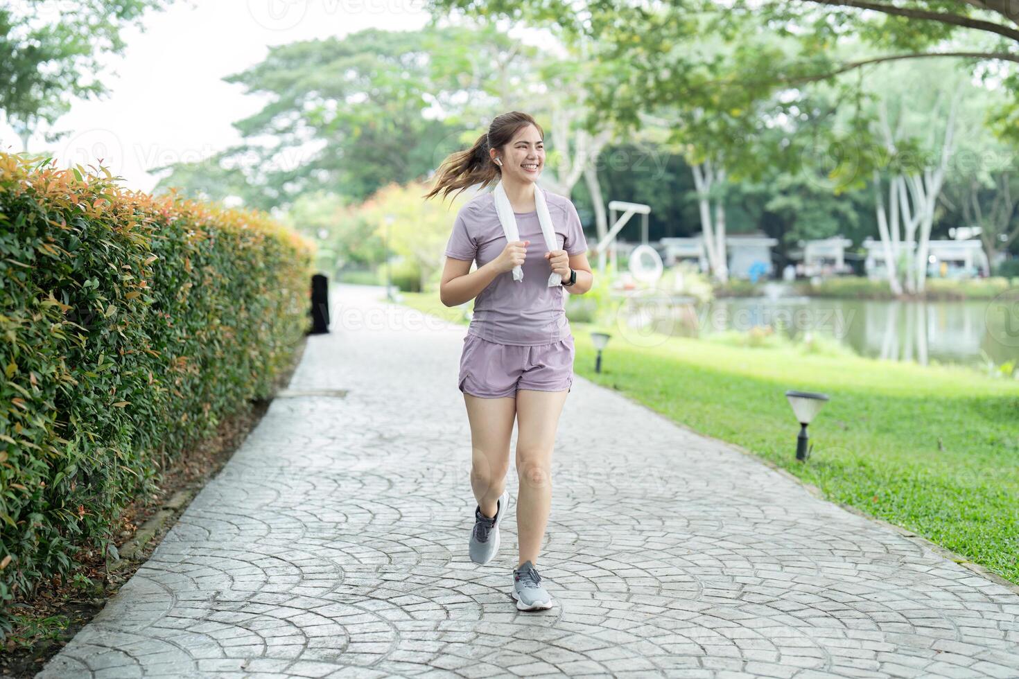 Young asian woman enjoying a morning run in a park. Workout exercise in the morning. Healthy and active lifestyle concept photo