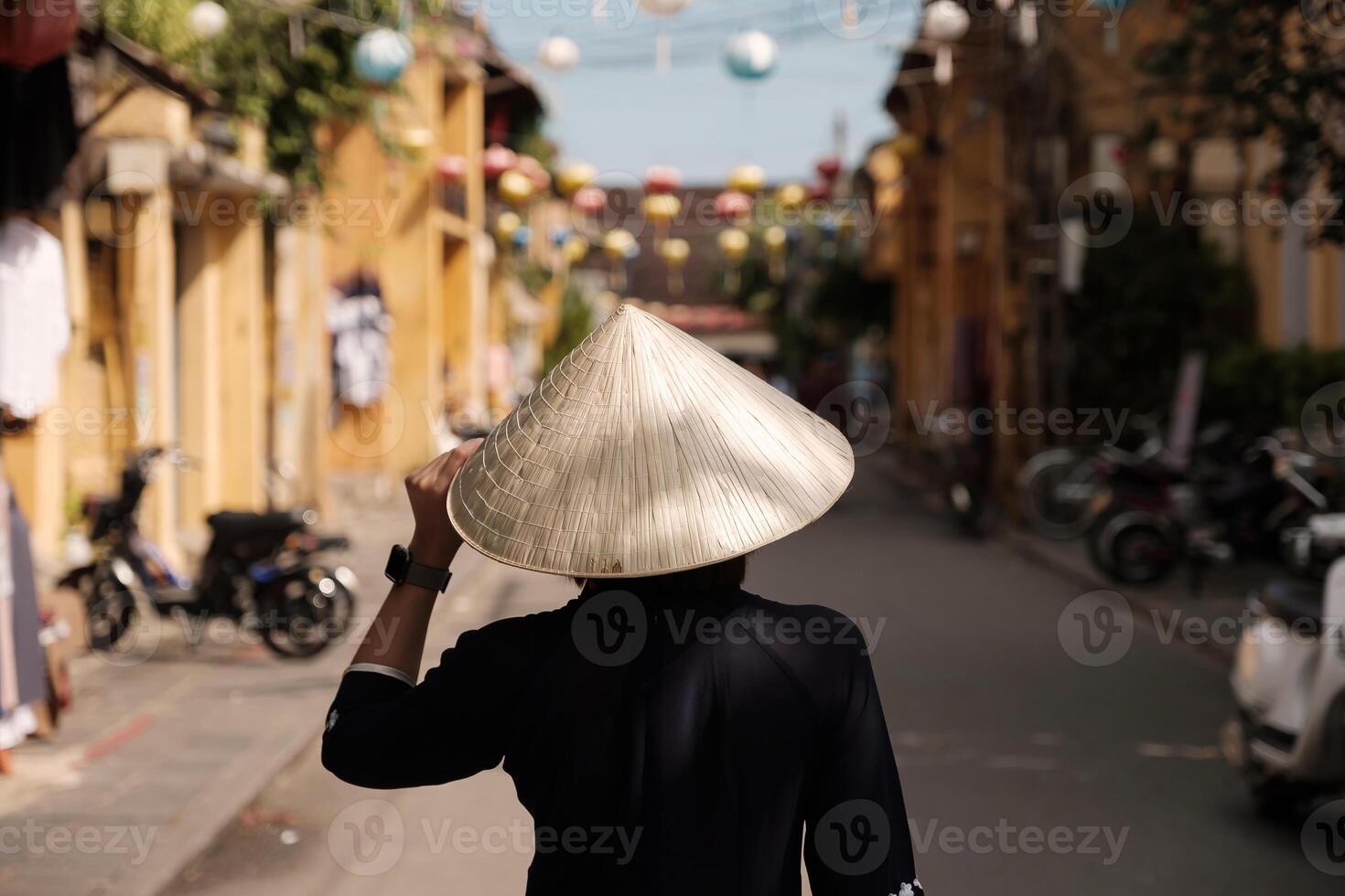 Beautiful girl wearing vietnam hat or Non La and sightseeing at Heritage village in Hoi An city in Vietnam photo