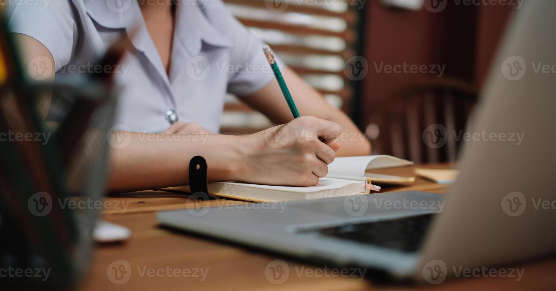 Close up student study online with teacher, young woman learn language listen lecture watch webinar write notes photo