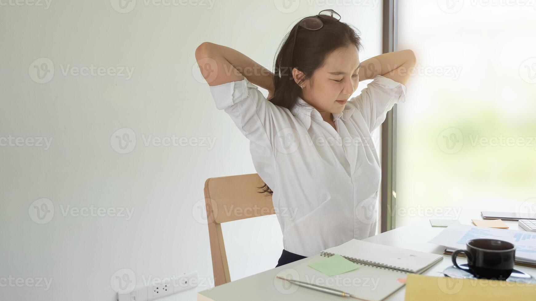 Businesswoman relaxing at comfortable in office hands behind head, happy woman resting in office satisfied after work photo