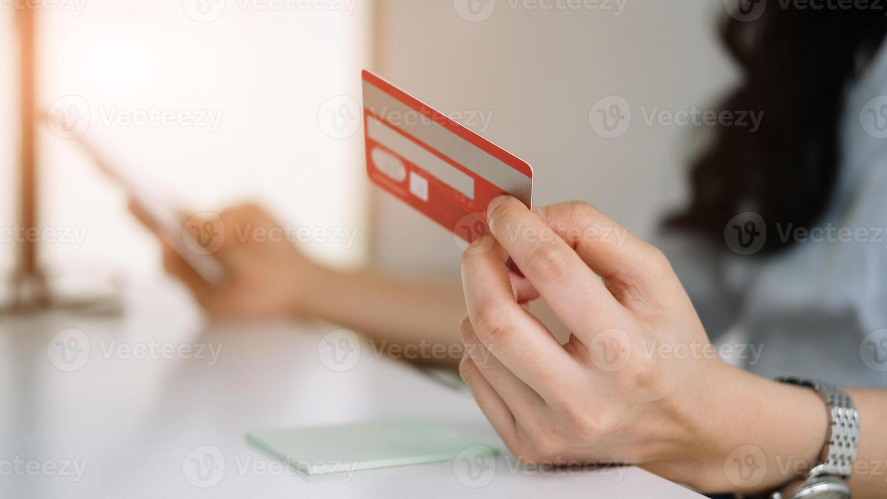 Close up woman using credit card for purchasing and shopping online on mobile phone photo