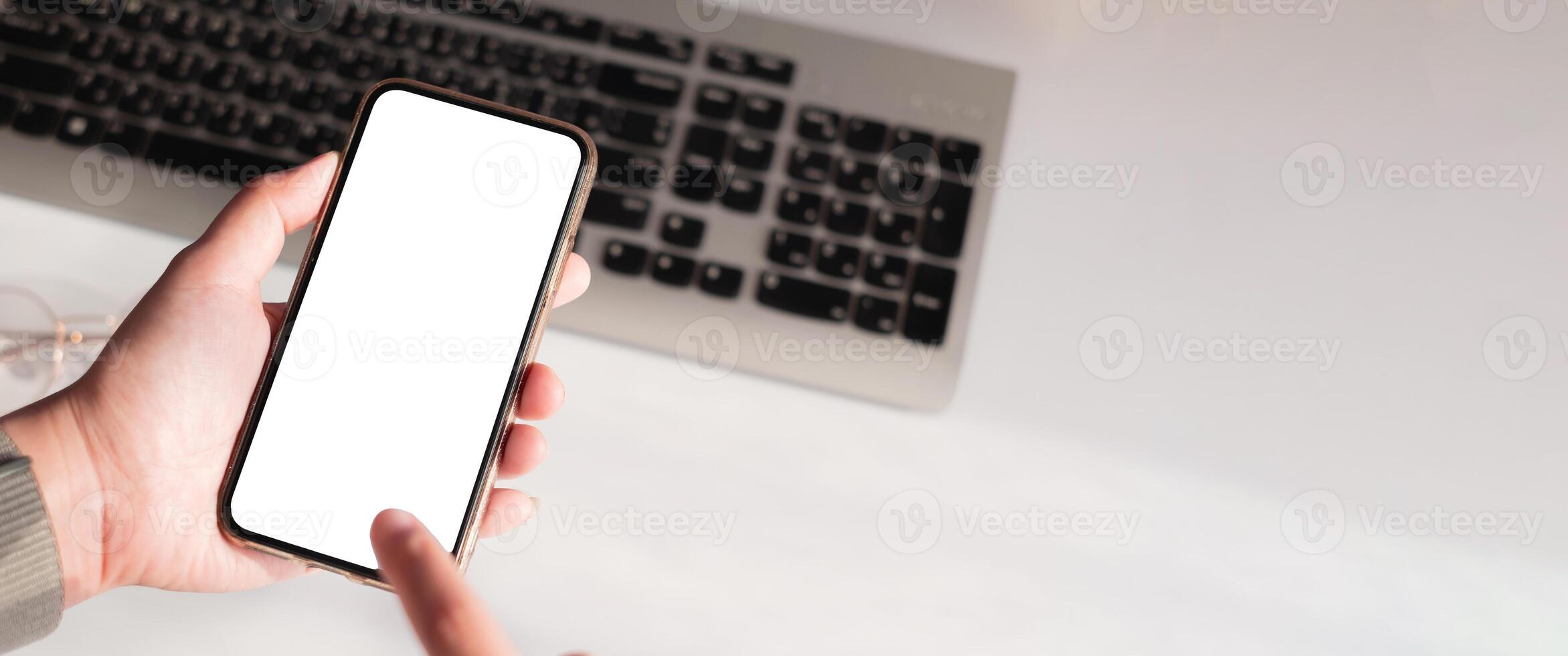 Hand of woman using smartphone over workplace photo