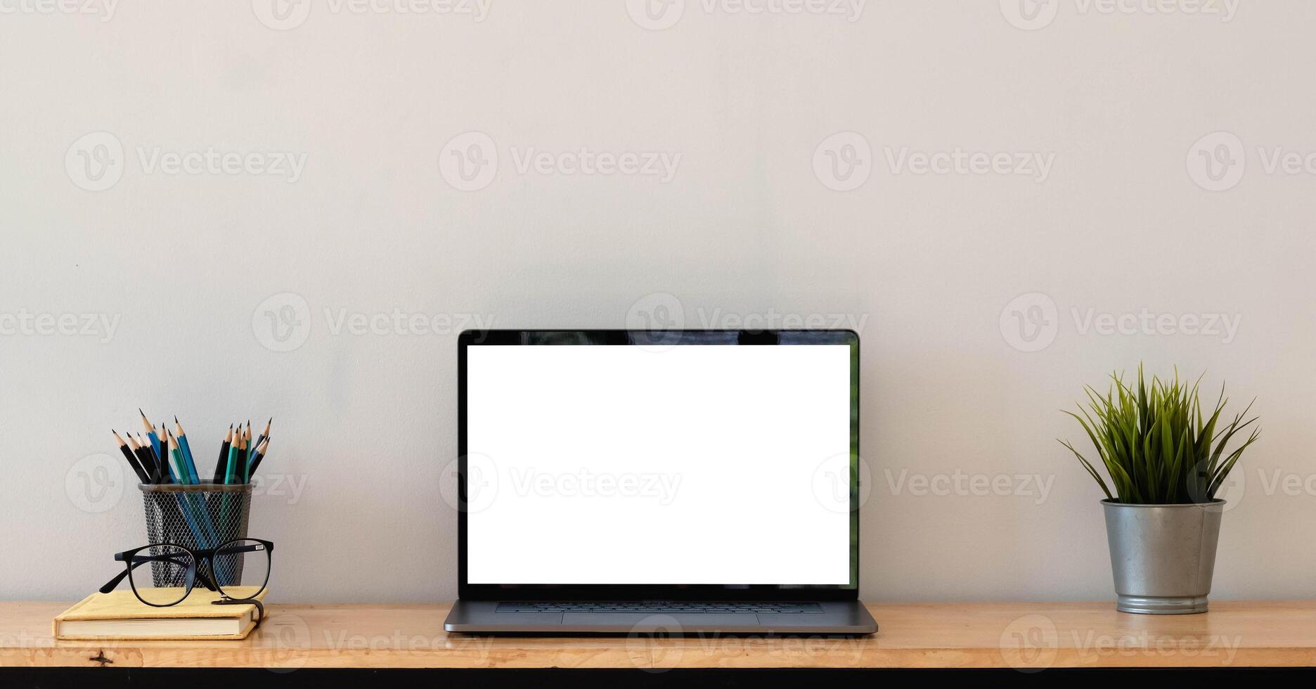 Cropped shot of simple workspace with blank screen laptop, cup, stationery and copy space photo