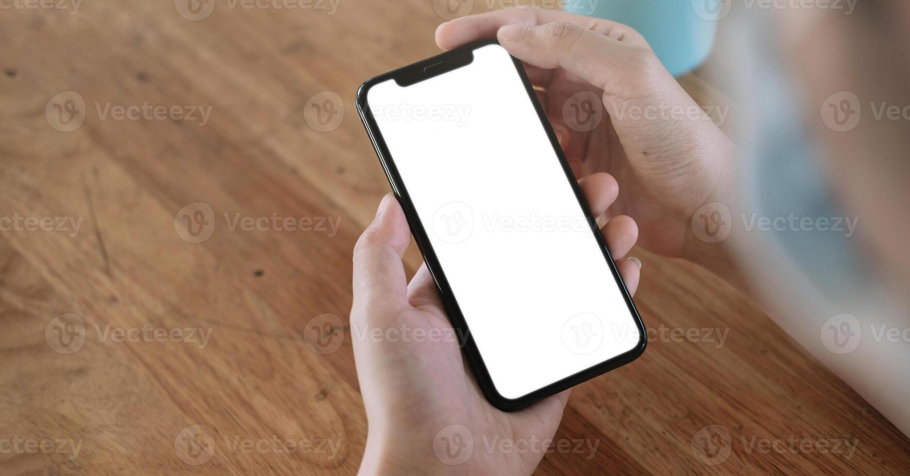 Top view Woman sitting and holding blank screen mock up mobile phone photo