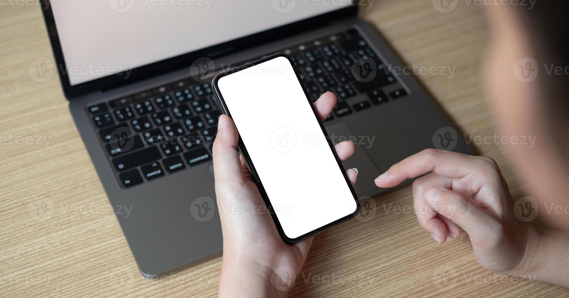 Woman using smartphone with blank screen on workplace photo