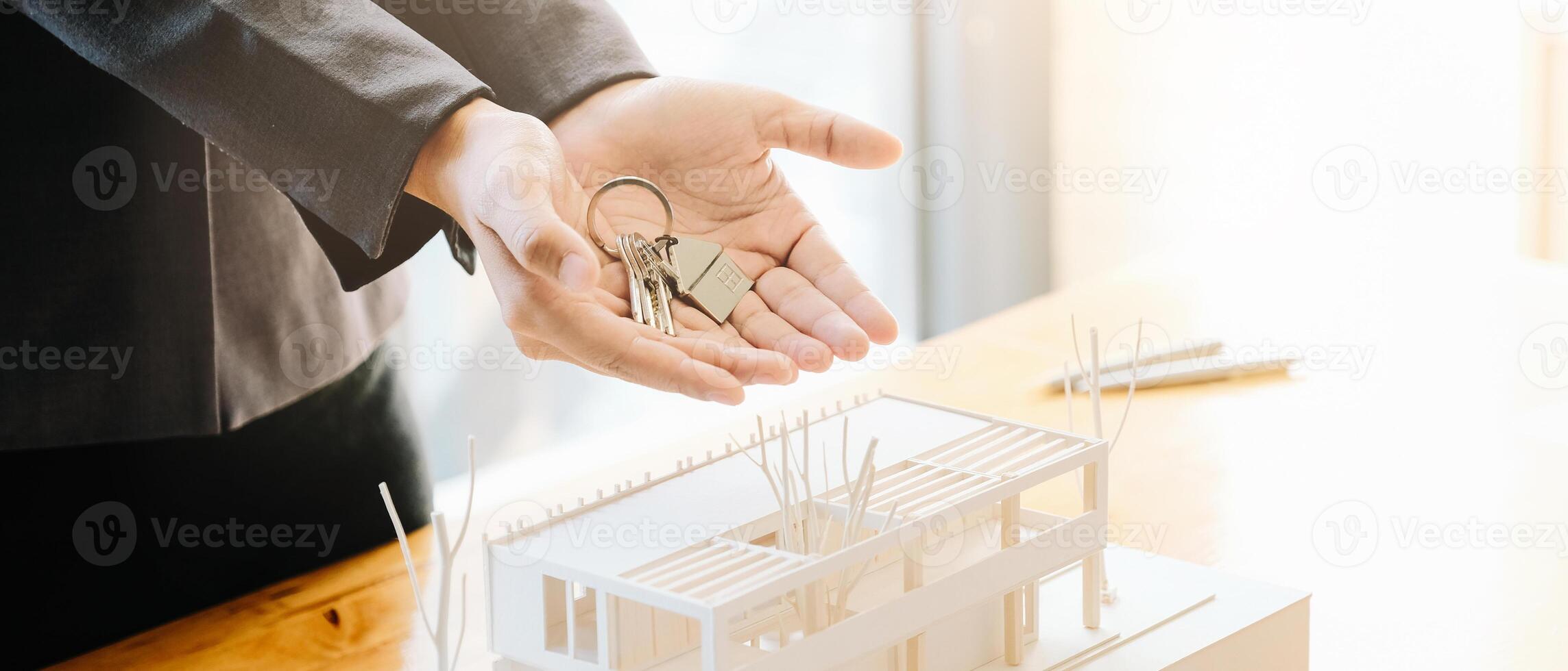 Real estate agent handing over house keys with approved mortgage application photo