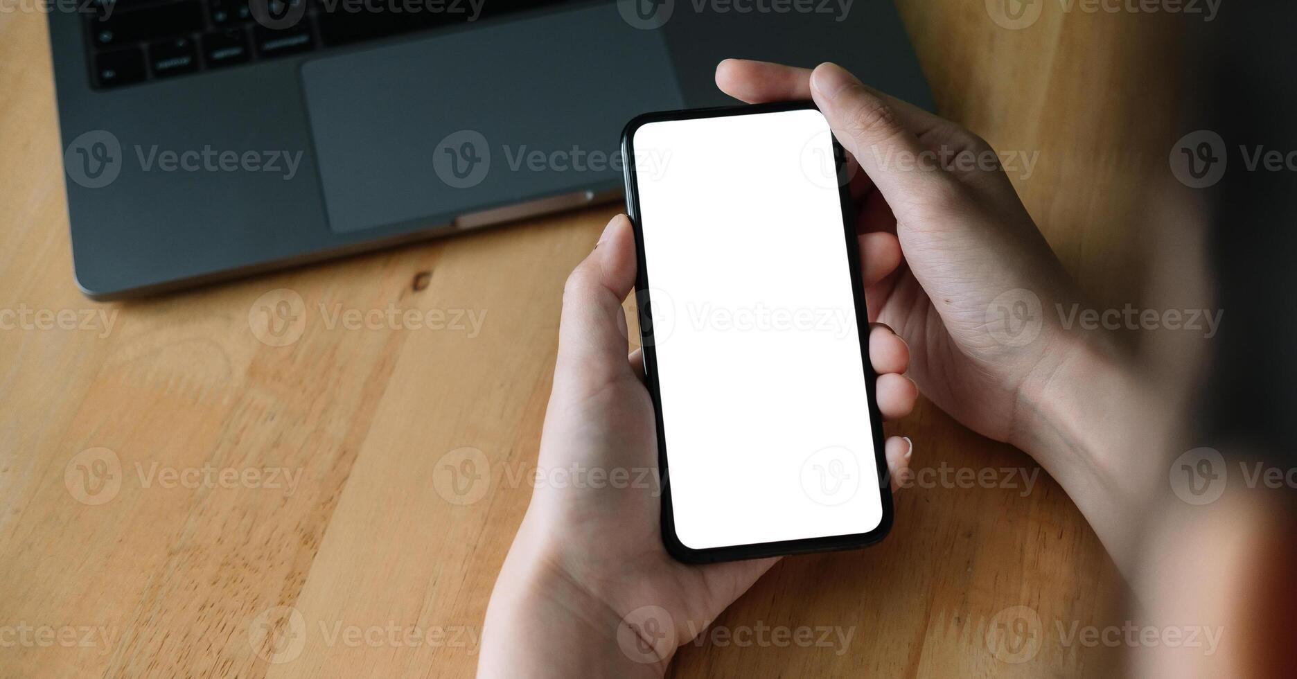oman hand holding smartphone on workplace. Blank screen mobile phone for graphic display montage.. photo