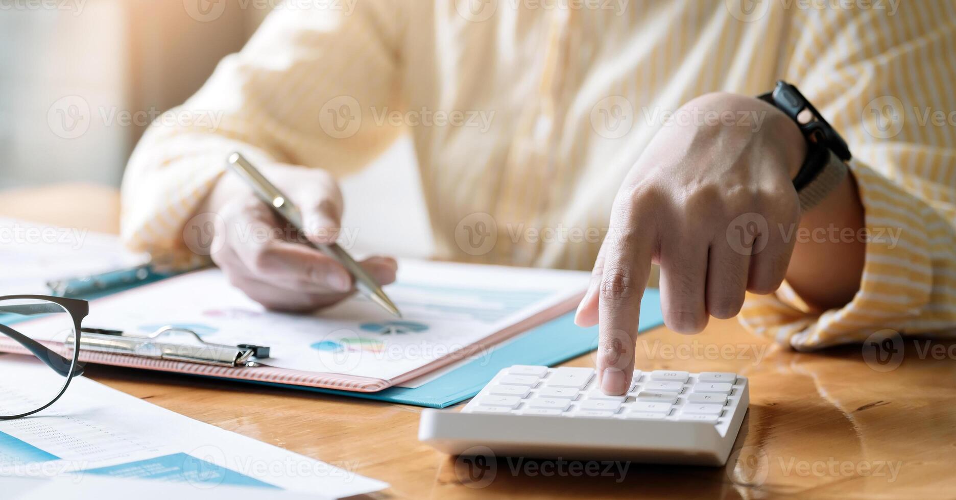 Accountant or bookkeeper working on desk using calculator, accounting finance concept. photo