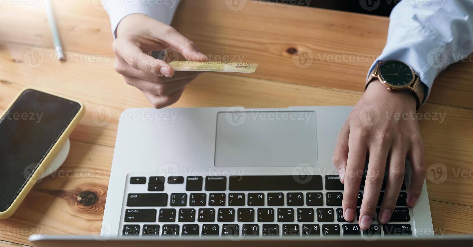 Close up hand of woman holding credit card and using laptop computer at home. Online shopping concept photo
