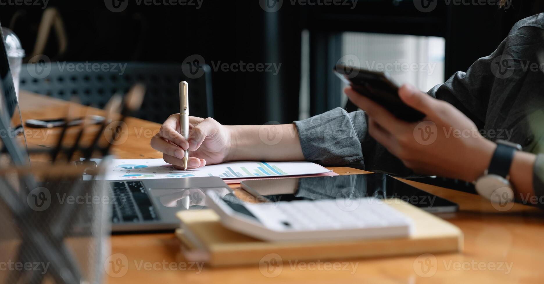 Businessman pen pointing turnover with graph chart report and use laptop computer for analysis data photo