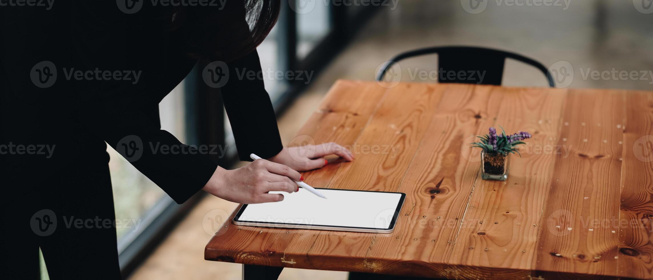 Close up hand of business woman working desk drawing on a white blank screen computer tablet photo