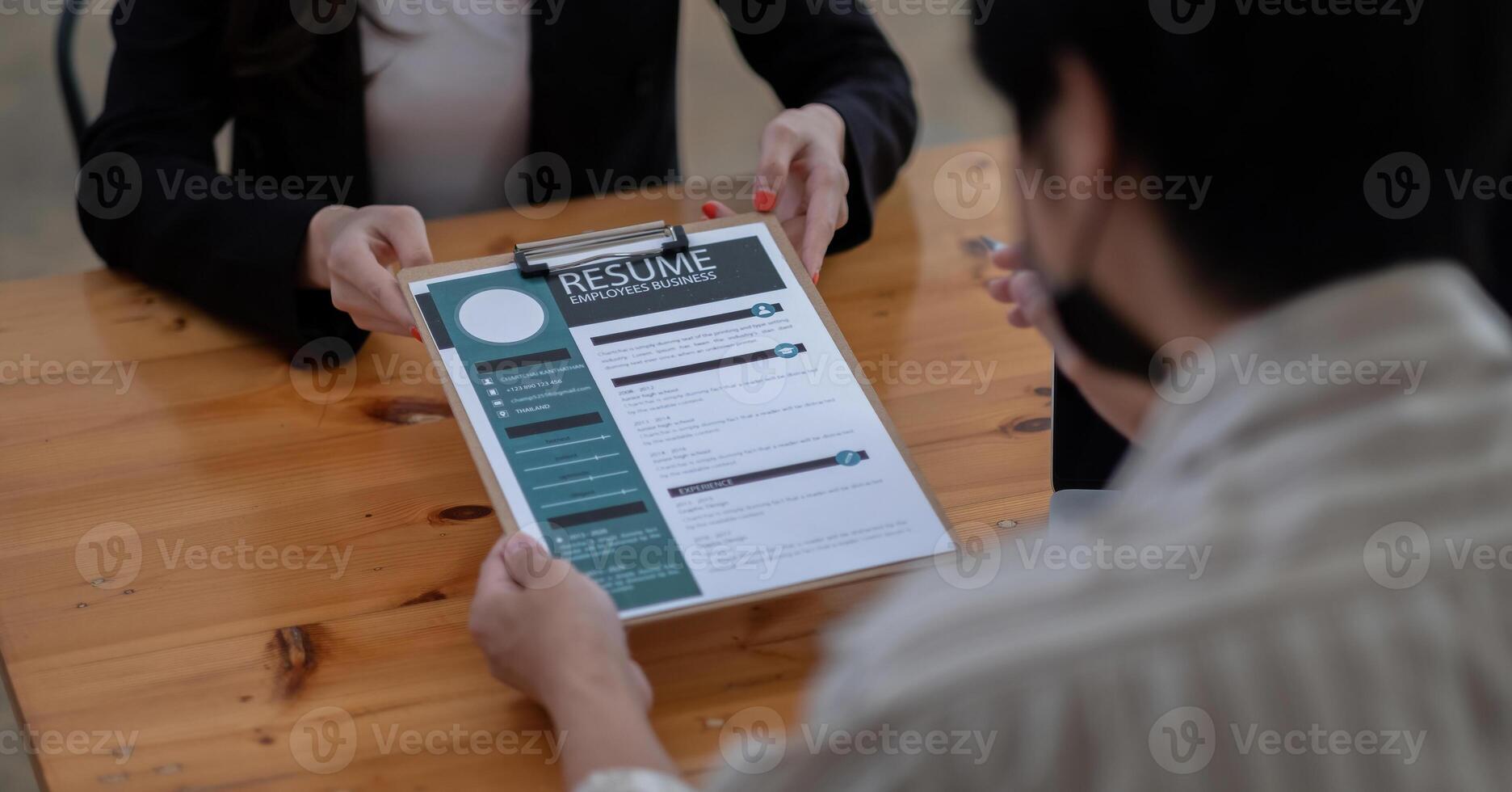 job interview in office, focus on resume writing tips, employer reviewing good cv of prepared skilled applicant, recruiter considering application, hr manager making hiring decision. photo