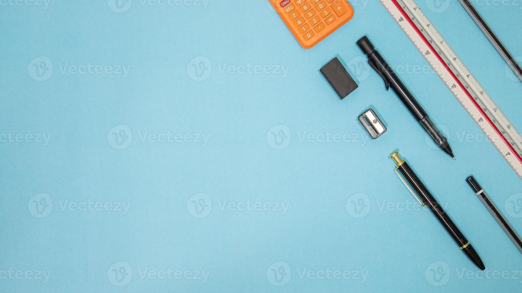 Education or back to school Concept. Top view of Colorful school supplies with books, color pencils, calculator, pen cutter clips and apple on blue pastel background. Flat lay. photo