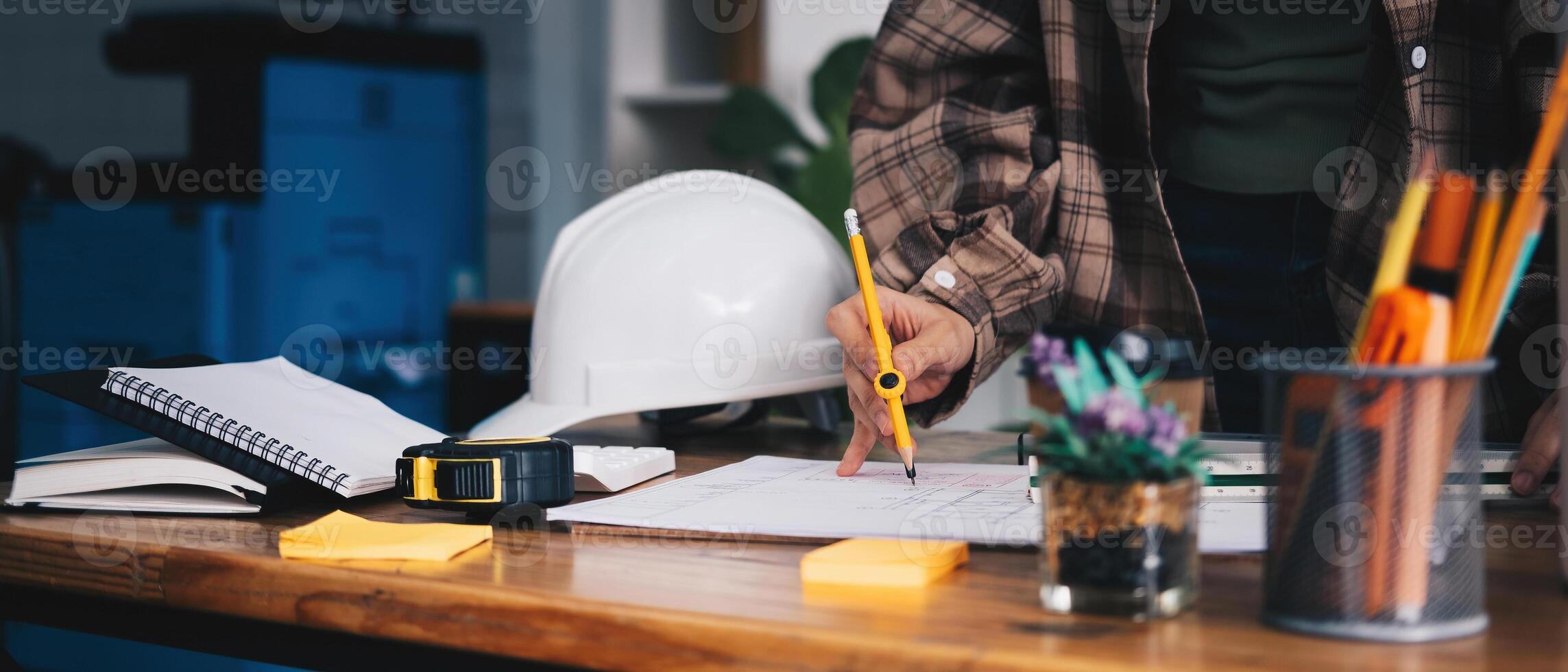 Cropped woman architect design working drawing sketch plans blueprints and making architectural construction model in architect studio. photo