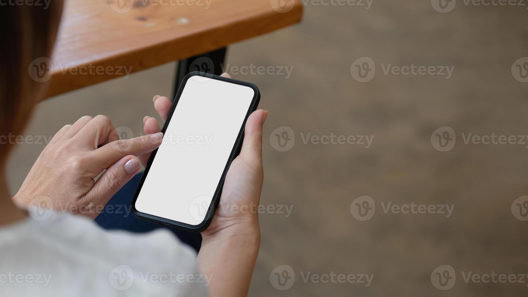 Top view Woman sitting and holding blank screen mock up mobile phone photo