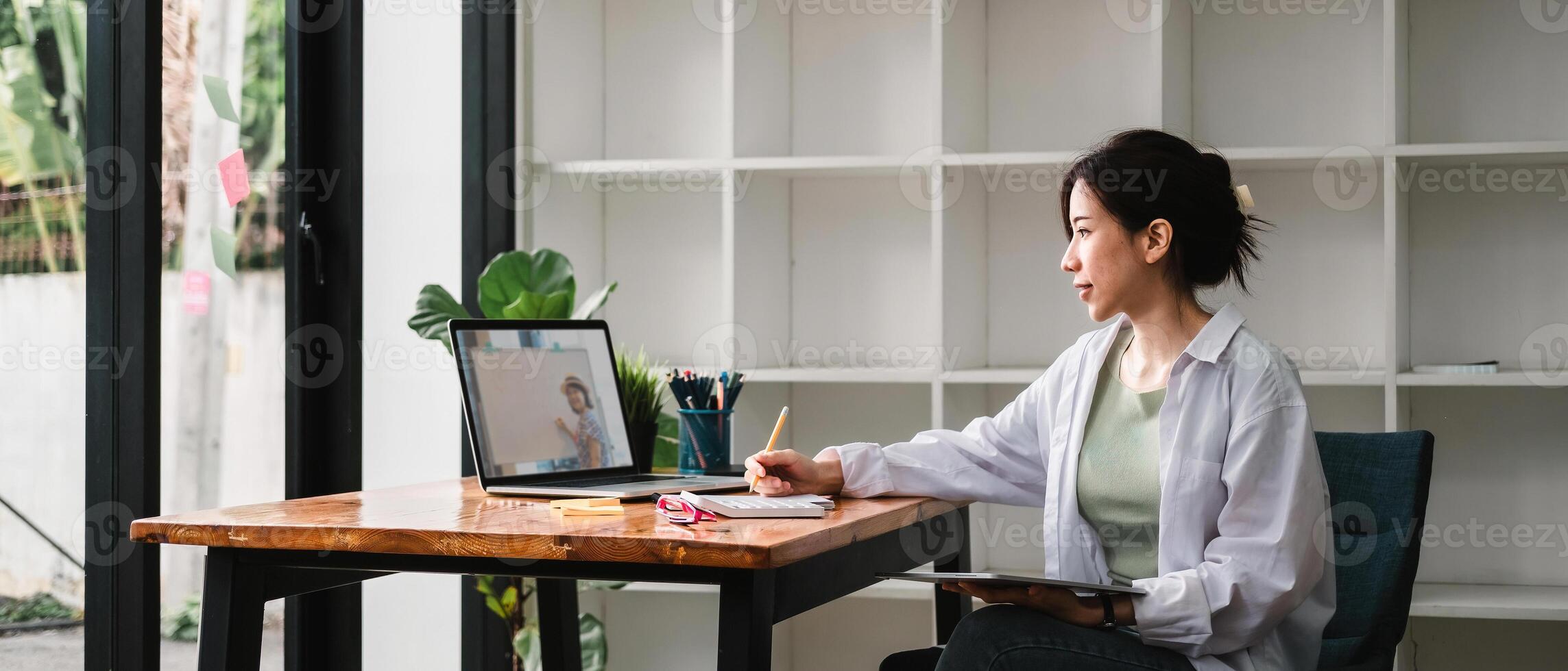 Cropped photo of woman writing making list taking notes in notepad working or learning on laptop indoors- educational course or training, seminar, education online concept