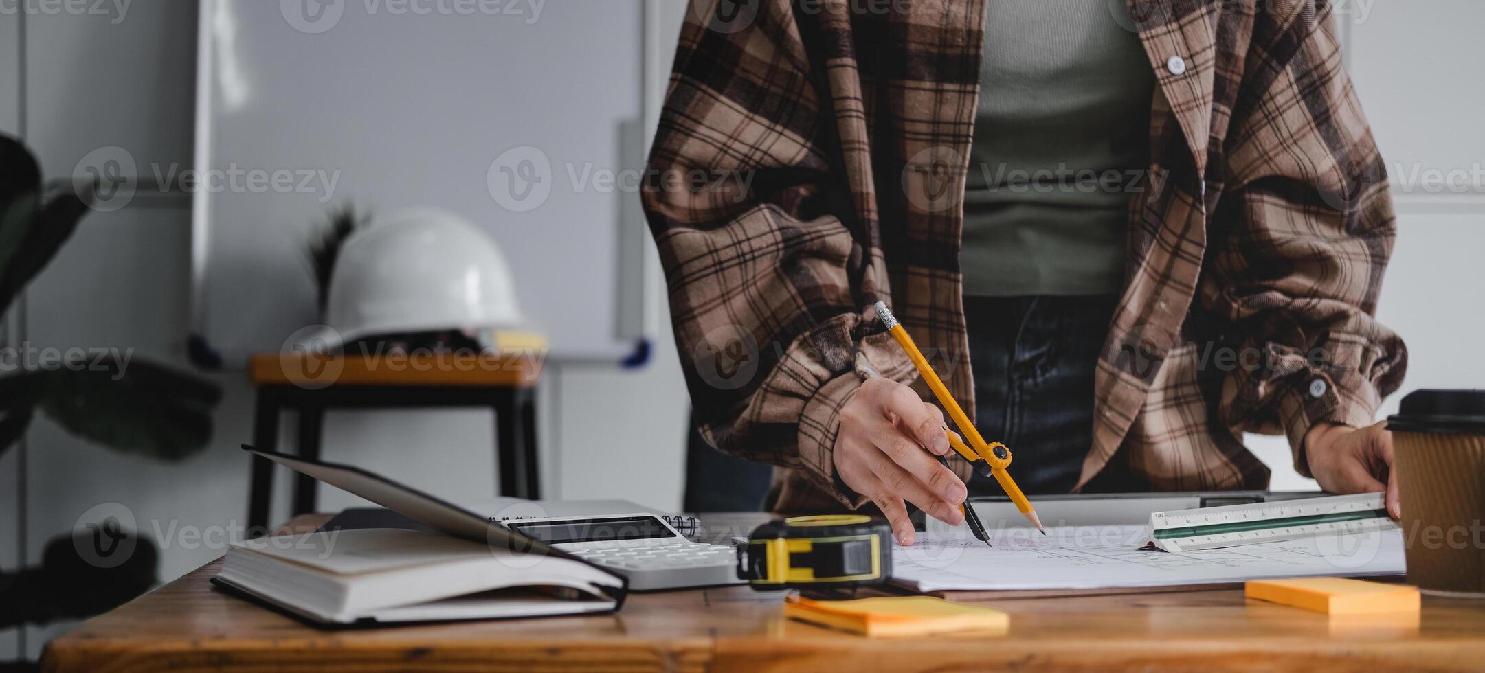 Cropped woman architect design working drawing sketch plans blueprints and making architectural construction model in architect studio. photo